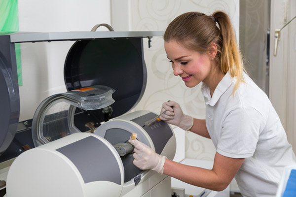 Dental assistant assisting with CEREC technology